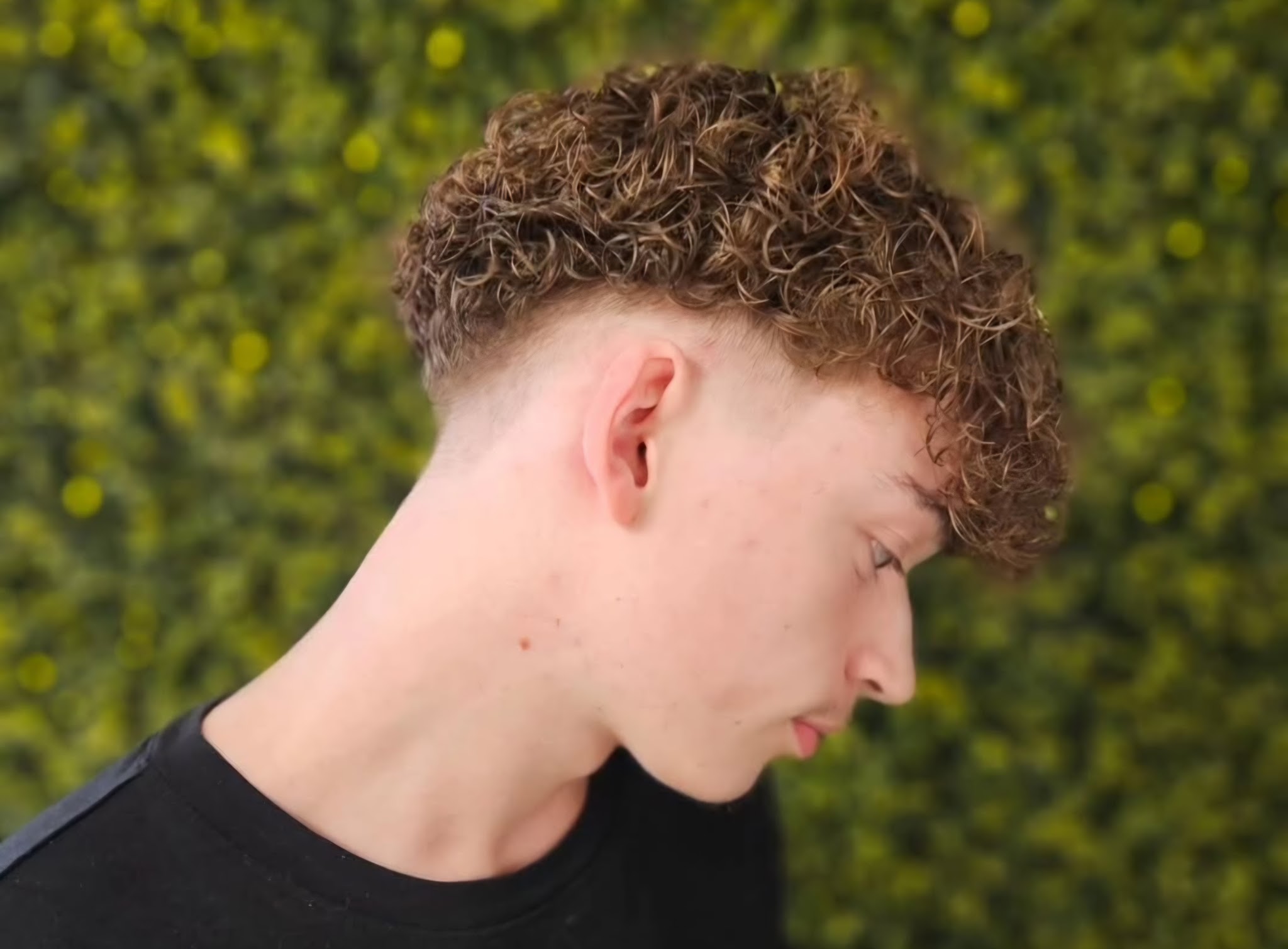 Krullen met een skin fade, voor de groene haagwand